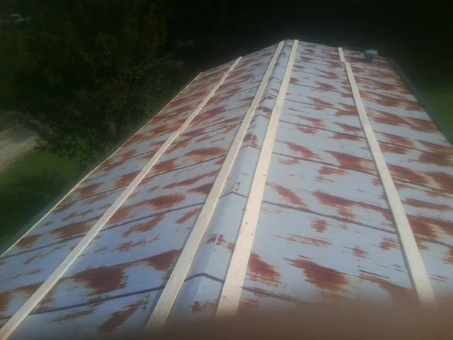 Rusted metal roof panels with new wood purlins before replacement — Storm Damage Roof Repair in Woodmere by Roofing Brothers