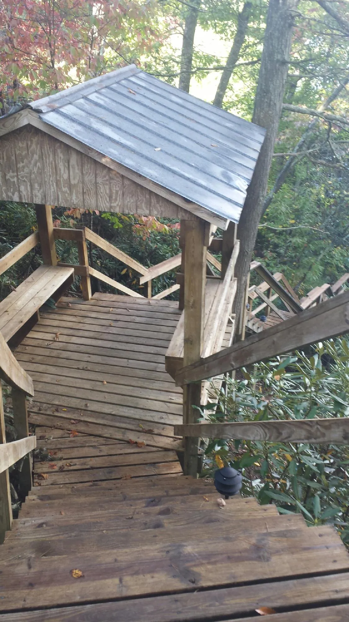 Metal roofed shelter over wooden steps on a wooded walkway — Skylight Repair & Installation work by our crew in Woodmere