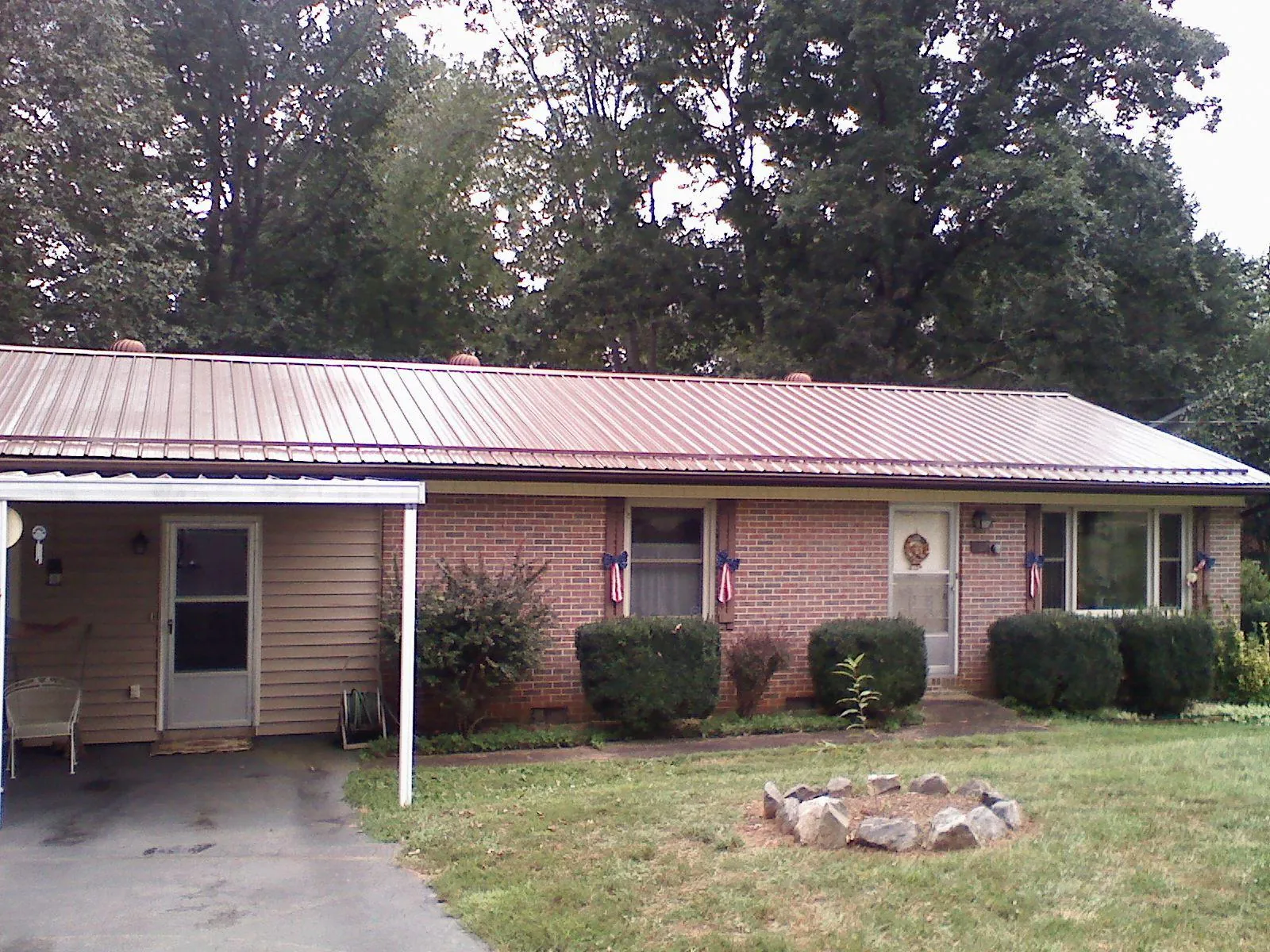 Bronze metal roof and carport on a brick ranch home — Roof Repair work by our crew in Woodmere